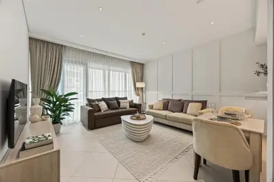 a living room with a couch and a table at Palm Jumeirah Sea-View Stay - Infinity Pool - Beach - Gym - Padel in Dubai