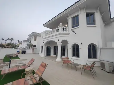 a large white building with chairs and a patio at BLVD Beach House in Dubai