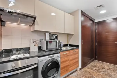 a kitchen with a washing machine and a washer at MarvelStay - Beach 5 mins - Fits 3 - Pool-Gym-Sauna - Marina in Dubai