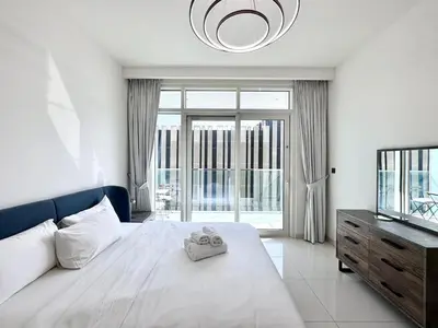 a bedroom with a bed and a large window at Direct Beach Access 2BHK in Dubai