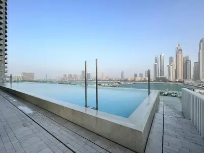 a swimming pool with a city skyline in the background at Direct Beach Access 2BHK in Dubai