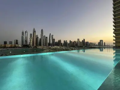 a swimming pool with a city skyline in the background at Direct Beach Access 2BHK in Dubai