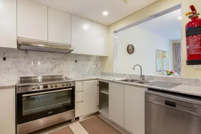 a kitchen with white cabinets and a stainless steel oven at Exclusive 2BR in Rahaal 2, Madinat Jumeirah Living in Dubai