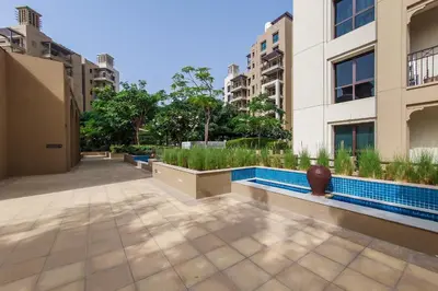 a courtyard of a building with a pool and buildings at Exclusive 2BR in Rahaal 2, Madinat Jumeirah Living in Dubai