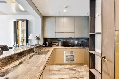 a kitchen with white cabinets and a sink at Lavish 2-Bedroom Apartment in Dubai Oasis in Dubai