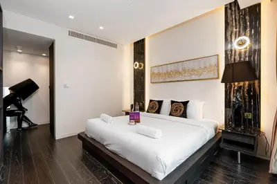 a bedroom with a large white bed and a piano at Lavish 2-Bedroom Apartment in Dubai Oasis in Dubai