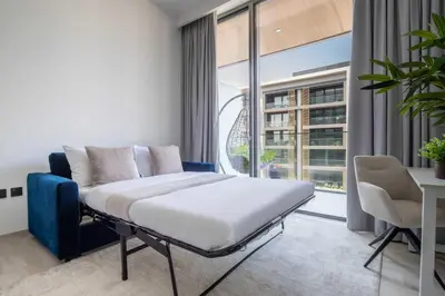 a bedroom with a bed and a large window at Frank Porter - Grove by Eman in Dubai