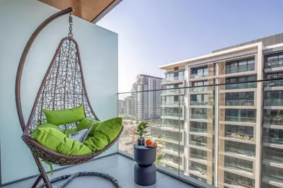 a hanging chair in a room with a large window at Frank Porter - Grove by Eman in Dubai