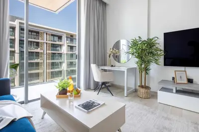 a living room with a tv and a large window at Frank Porter - Grove by Eman in Dubai