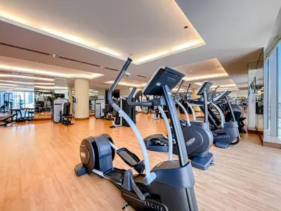a gym with rows of treadmills and elliptical machines at Two Bedroom with Full marina view in Dubai