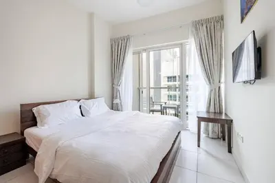 a white bedroom with a bed and a window at Two Bedroom with Full marina view in Dubai