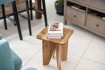 a book on a wooden table in a living room at Beachfront Boho Bliss Direct Beach Access in Dubai