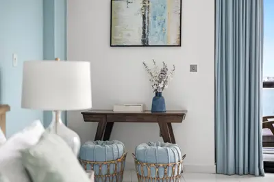 a living room with a table and two stools at Beachfront Boho Bliss Direct Beach Access in Dubai