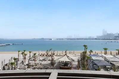 a view of the beach from the balcony of a resort at Beachfront Boho Bliss Direct Beach Access in Dubai