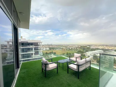 a balcony with two chairs and a table on a building at Greenery Haven 2 Bed plus Study in Damac Hills in Dubai