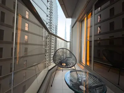 a balcony with two chairs and a table in a building at Elite Studio with Burj Khalifa & Pool View in Dubai