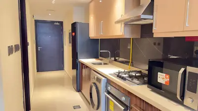 a kitchen with a sink and a stove at Elite Studio with Burj Khalifa & Pool View in Dubai