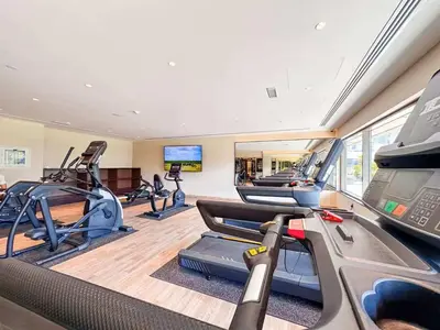 a gym with several treadmills and cardio machines at Elite Studio with Burj Khalifa & Pool View in Dubai