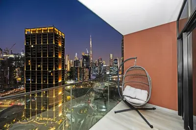 a chair on a balcony with a view of a city at Stylish Studio with Burj Khalifa Views in Dubai