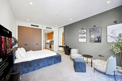 a bedroom with a bed and a living room at Stylish Studio with Burj Khalifa Views in Dubai