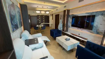a living room with a couch and a tv at Beachside Palm Jumeirah 1 Br apartment in Dubai