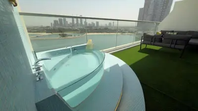 a hot tub on the balcony of a building at Beachside Palm Jumeirah 1 Br apartment in Dubai