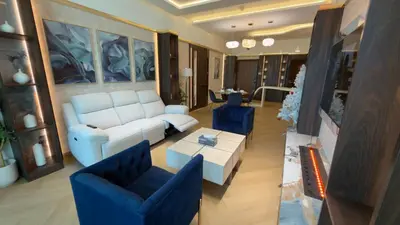 a living room with a white couch and blue chairs at Beachside Palm Jumeirah 1 Br apartment in Dubai