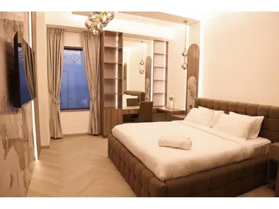a bedroom with a bed and a desk and a window at The bahar bloom stay in Dubai