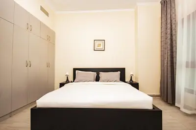a bedroom with a large bed with white sheets at Brand New 2BHK Fully Furnished Apartment in Warsan in Dubai