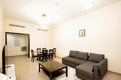 a living room with a couch and a table at Brand New 2BHK Fully Furnished Apartment in Warsan in Dubai