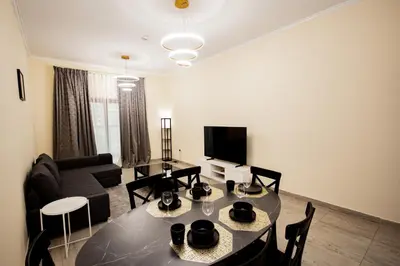 a living room with a table and a couch at Brand New 2BHK Fully Furnished Apartment in Warsan in Dubai