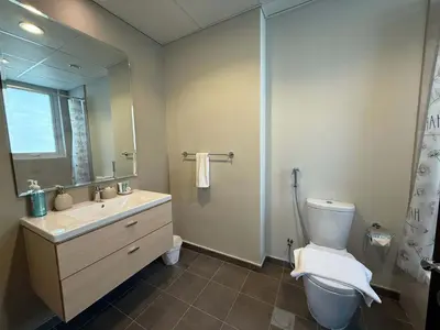 a bathroom with a sink and a toilet and a mirror at Spacious Fully Furnished 6BR Villa in Damac Hill2 in Dubai