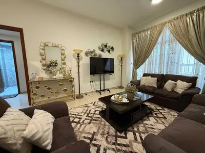 a living room with a couch and a tv at Stylish & Fully Furnished 1BR in Laya Residence in Dubai