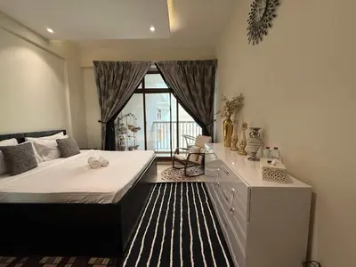 a bedroom with a large bed and a window at Stylish & Fully Furnished 1BR in Laya Residence in Dubai