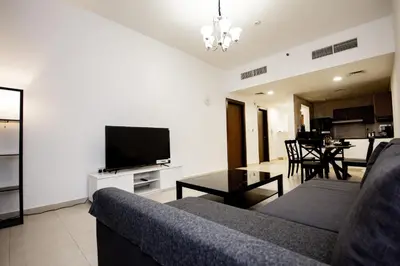 a living room with a couch and a flat screen tv at Newly Furnished 1BHK Apartment in Maya Residency in Dubai