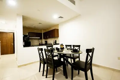 a dining room with a table and chairs in a kitchen at Newly Furnished 1BHK Apartment in Maya Residency in Dubai