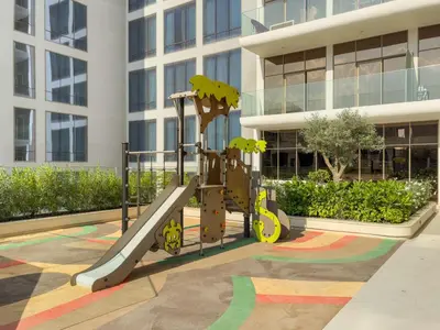a playground in front of a building at VayK - Refined 1 BD Apartment in JVC in Dubai
