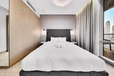 a bedroom with a large white bed and a window at Vida Residences Dubai Mall - Burj Khalifa View, Downtown Dubai in Dubai