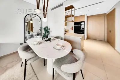 a kitchen and dining room with a white table and chairs at Vida Residences Dubai Mall - Burj Khalifa View, Downtown Dubai in Dubai