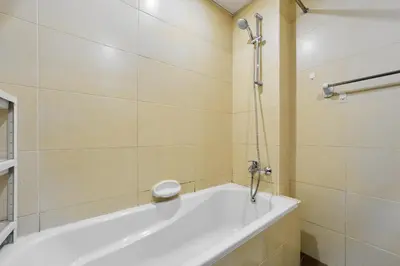 a white bath tub in a bathroom with a shower at Peaceful 1BR with Balcony at Elite Residence Dubai in Dubai