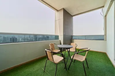 a table and chairs in a room with a window at Peaceful 1BR with Balcony at Elite Residence Dubai in Dubai