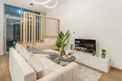 a living room with a white couch and a tv at Luxury 2BHK with Floating Bed in Dubai Marina DEC1105 in Dubai