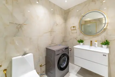 a bathroom with a washing machine and a sink at Luxury 2BHK with Floating Bed in Dubai Marina DEC1105 in Dubai