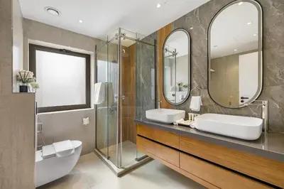 a bathroom with two sinks and two mirrors at 2BR Marina View Steps from the Beach in Dubai