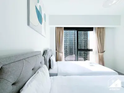 a bedroom with two white beds and a window at Skyline Escape 2BR Stay with balcony, Pool & Gym in Dubai