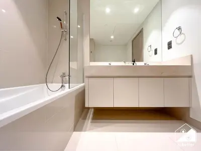 a white bathroom with a shower and a sink at Skyline Escape 2BR Stay with balcony, Pool & Gym in Dubai