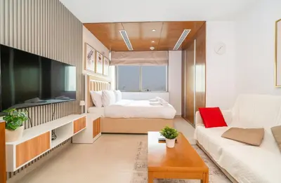 a living room with a bed and a couch at Zapbed House-Modern Studio Apartment in Dubai Sports City in Dubai