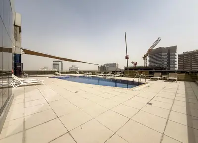 a swimming pool on the roof of a building at Zapbed House-Modern Studio Apartment in Dubai Sports City in Dubai