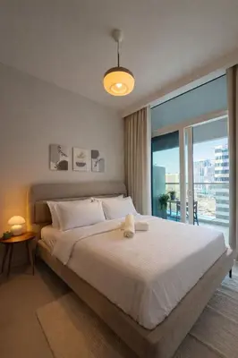 a bedroom with a large bed and a large window at Modern 1BR Apt - Canal View in Dubai