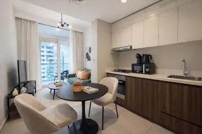 a kitchen and living room with a table and chairs at Modern 1BR Apt - Canal View in Dubai